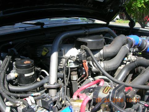 1996 Ford Bronco - Close-up view of an engine bay, showing complex mechanical components and wiring.