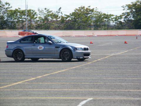 2001 Mercury Grand Marquis - Silver BMW M3 E46 on a race track with cones, another car in the background.