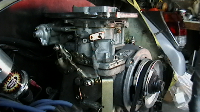 Aftermarket carburetor and linkage in the engine bay of a 1970 VW Beetle, with belt pulley visible