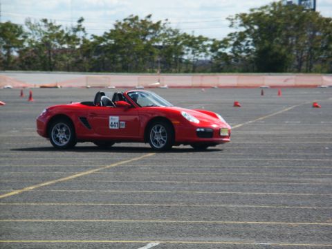 2001 Mercury Grand Marquis - A red convertible sports car navigates a course marked by cones on a sunny day.