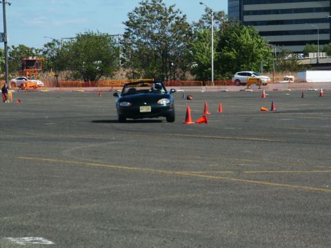 2001 Mercury Grand Marquis - A dark green convertible navigates a course marked by orange cones, with other vehicles visible in the background.
