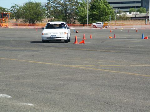 2001 Mercury Grand Marquis - A white 2001 Mercury Grand Marquis navigates an autocross course marked by orange cones.