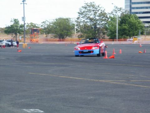 2001 Mercury Grand Marquis - Red convertible sports car with blue front bumper navigates a course marked by orange cones.