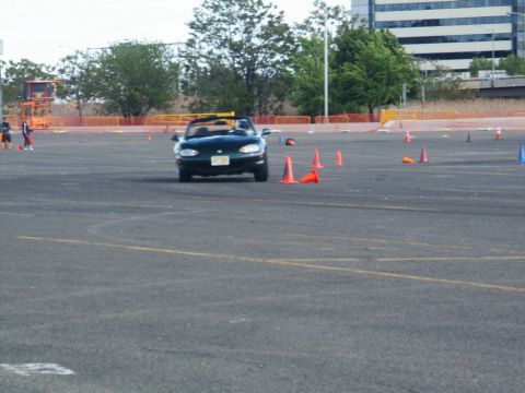 2001 Mercury Grand Marquis - A green convertible sports car is seen driving through an autocross course with orange cones.