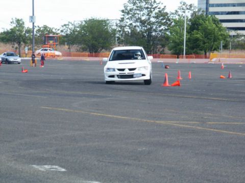 2001 Mercury Grand Marquis - A white sports sedan is driven through a cone course in a parking lot, with another car visible in the distance.