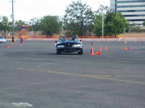 2001 Mercury Grand Marquis - A black convertible sports car navigates a course marked by orange cones on a paved lot.