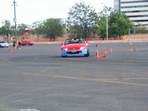 2001 Mercury Grand Marquis - A two-tone red and blue sports car drives through a cone-marked course, likely during a timed event.