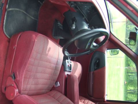 1996 Ford Bronco - Interior view of a red vehicle, focusing on the driver's seat and steering wheel.