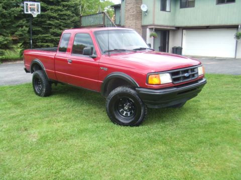 1996 Ford Bronco - This red Ford Ranger pickup truck is shown from a 3/4 front angle on a grassy lawn.