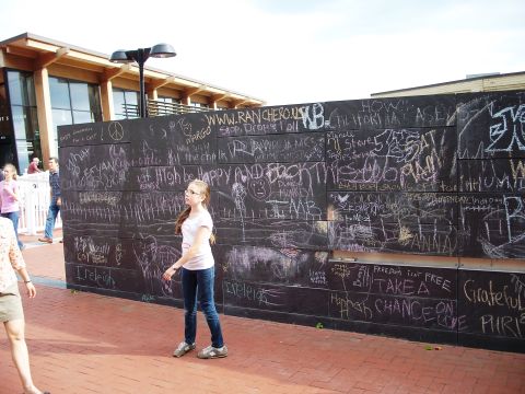 1971 Ford Ranchero - A group of people are near a large wall covered in chalk drawings and writing.