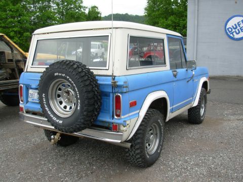 1975 Ford Bronco - Rear view of a 1975 Ford Bronco, showing its spare tire and two-tone paint scheme.