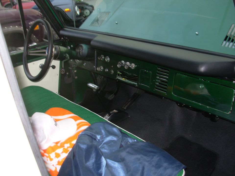 Green painted dash and bench seat interior of a restored early Ford Bronco