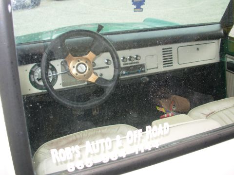 1975 Ford Bronco - Interior view of a 1975 Ford Bronco, a custom steering wheel and "ROB'S AUTO & OFF ROAD" decal.