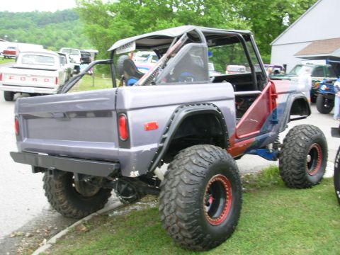 1975 Ford Bronco - Modified Ford Bronco with custom roll cage and oversized tires is parked outdoors.