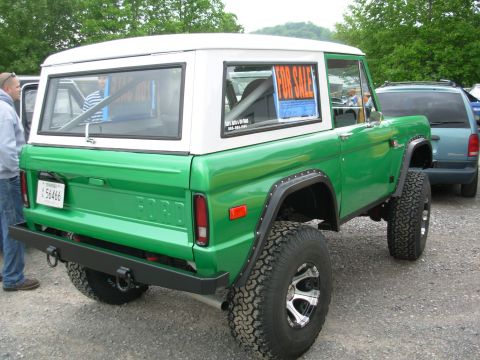 1975 Ford Bronco - A green 1975 Ford Bronco is parked outside with a 'For Sale' sign in the window.