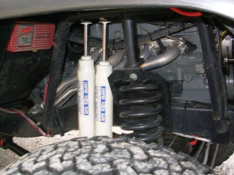 1975 Ford Bronco - Close-up view of engine and suspension components, including shocks and exhaust.