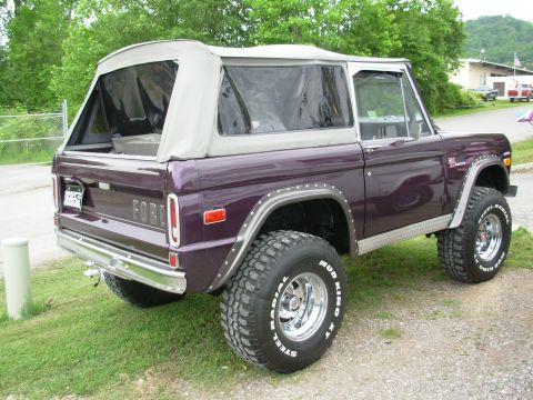 1975 Ford Bronco - This 1975 Ford Bronco features a purple exterior, a removable soft top, and is shown in a rear 3/4 view.