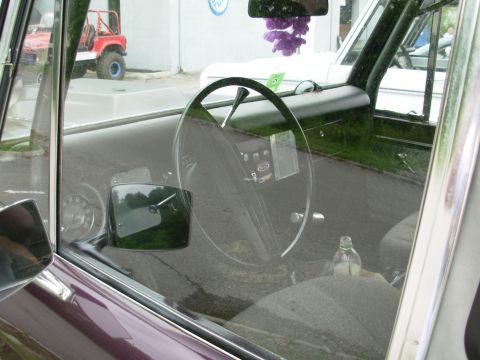 1975 Ford Bronco - Interior of a 1975 Ford Bronco, with a red Jeep visible through the window.
