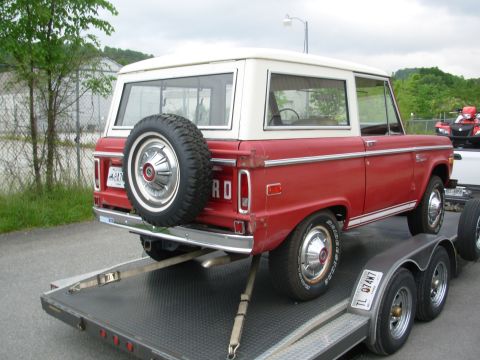 1975 Ford Bronco - This 1975 Ford Bronco is being transported on a trailer, showing its classic rear-end design and red paint.