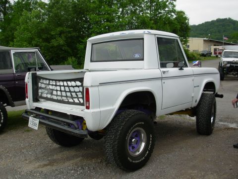 1975 Ford Bronco - A white 1975 Ford Bronco is parked outdoors next to another vehicle.