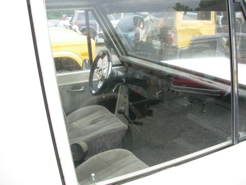 1975 Ford Bronco - Interior view of a 1975 Ford Bronco, with other vehicles seen through the windows.