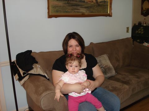 2000 Ford Crown Victoria - A woman and a baby sit on a couch in a living room.