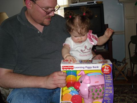 2000 Ford Crown Victoria - A father and his baby daughter interact with a Fisher-Price Learning Piggy Bank toy.
