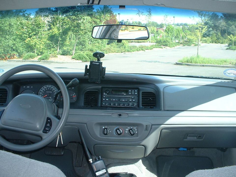 Interior of a 2000 Ford Crown Victoria dashboard with steering wheel, radio, and scanner.