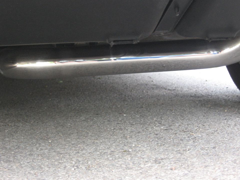 Underside of a vehicle showing a chrome exhaust pipe.