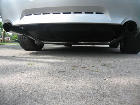 1998 Ford Taurus - The rear underside of a silver sedan is shown, featuring dual exhaust pipes and tires. The vehicle is parked on an asphalt surface with sca…