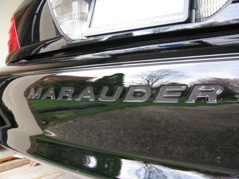 Chrome MARAUDER badge on glossy black sedan trunk lid