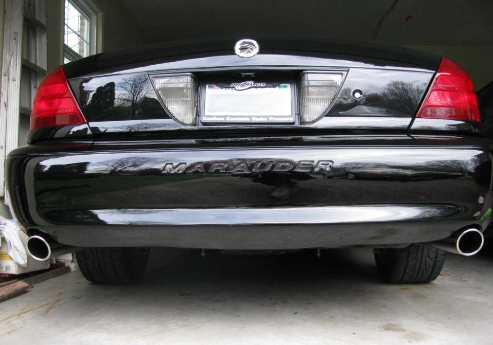 Rear of a black Mercury Marauder with chrome MARAUDER bumper lettering and dual polished exhaust tips