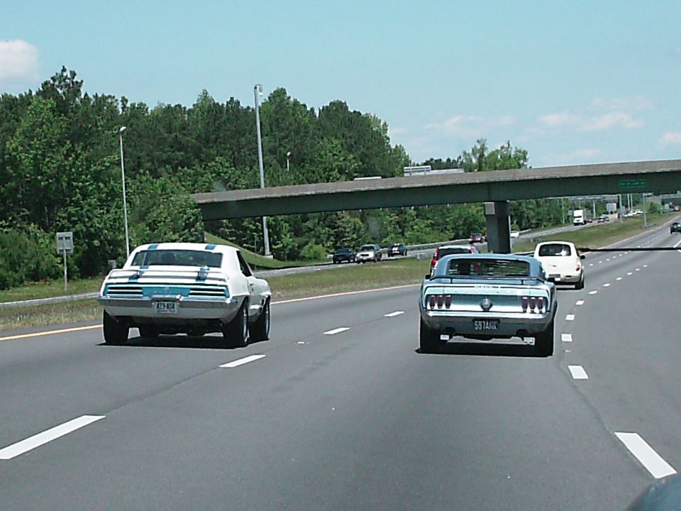 Light blue 1970 Ford Mustang Fastback driving on a highway.