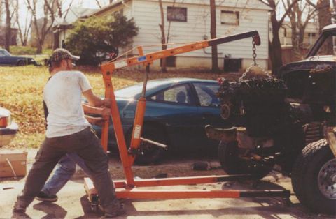 1978 Ford Bronco - An engine is being lifted out of a vehicle using an engine hoist.