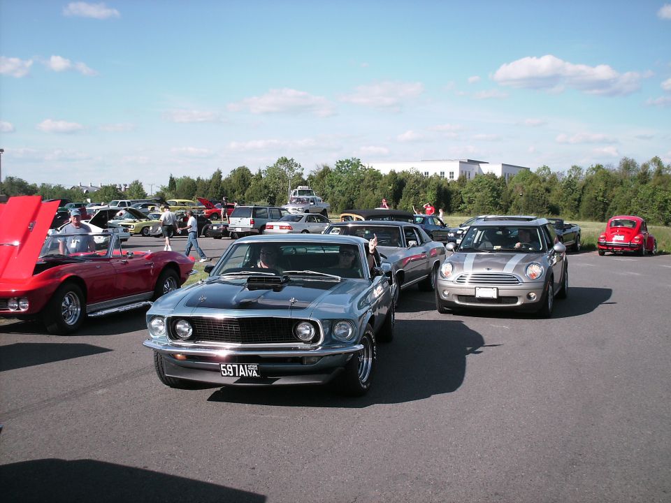 Silver 1970 Ford Mustang Fastback with hood open at a car show.