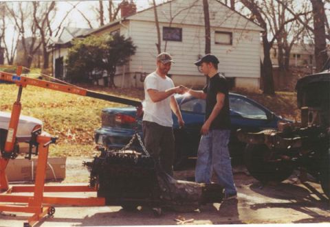 1978 Ford Bronco - Engine hoist is positioned to lift an engine, with two men in the background.