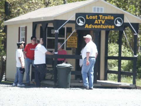 2001 Mercury Grand Marquis - A group of people gather outside a small building advertising ATV adventures.