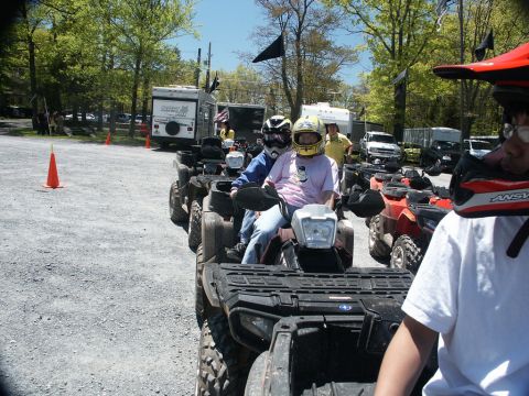 2001 Mercury Grand Marquis - A group of ATVs are lined up and ready for an outdoor adventure, with people geared up and waiting.