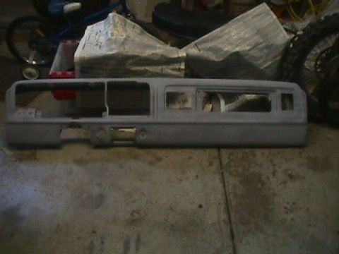 1978 Ford Bronco - A gray dashboard assembly is shown, likely for a vintage vehicle, with openings for instruments and controls.