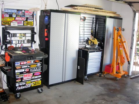 1993 Ford Bronco - A cluttered garage scene displays various tools, storage solutions, and automotive equipment.