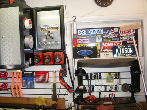 1993 Ford Bronco - A sticker for a Ford Bronco is displayed on a garage cabinet alongside tools and other automotive-themed memorabilia.