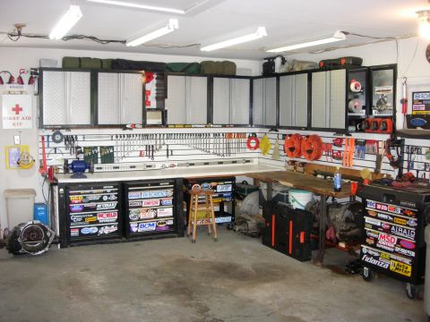 1993 Ford Bronco - A well-organized garage workshop is filled with tools, storage cabinets, and automotive parts.
