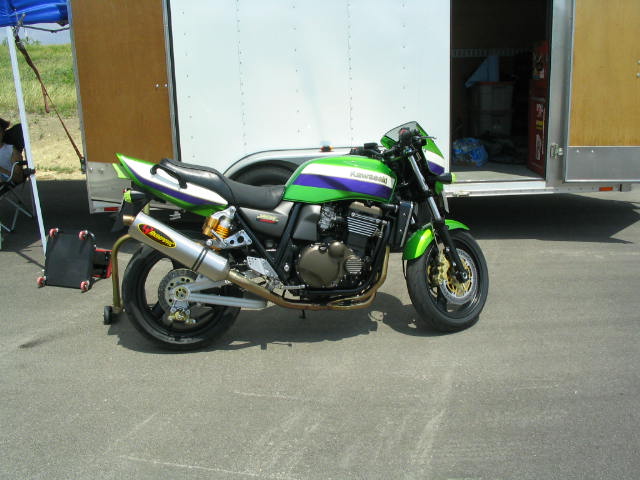 Green Kawasaki naked motorcycle parked beside a trailer