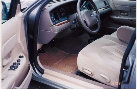 2002 Ford Crown Victoria - The interior of a 2002 Ford Crown Victoria is visible, the dashboard, steering wheel, and driver's seat.