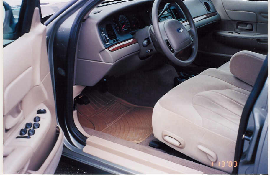 Beige interior of Ford sedan viewed from open driver's door