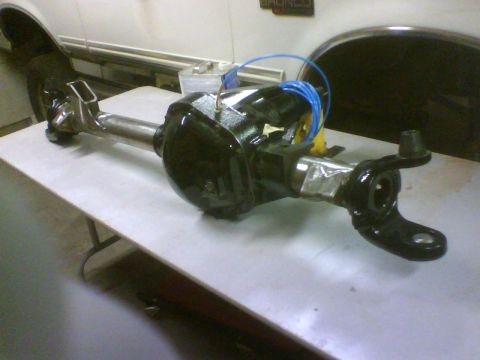 1993 Ford Bronco - A differential axle assembly is shown on a table, with blue tubing connected to its black casing.