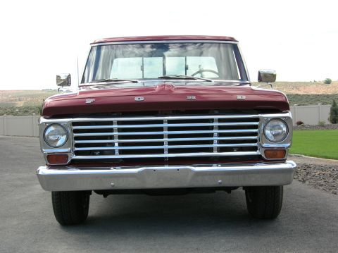 1967 Ford F-100 - Front view of a red 1967 Ford F-100 pickup truck a prominent chrome grille and Ford badging.