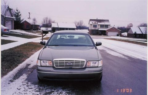 2002 Ford Crown Victoria - A gray Ford Crown Victoria is parked on a residential street during winter.