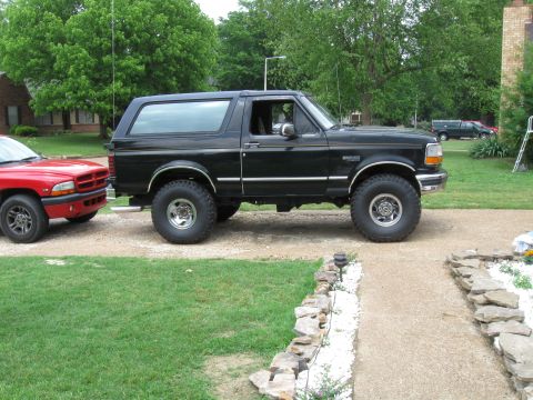 1994 Ford Bronco - A black 1994 Ford Bronco is parked next to a red Dodge Dakota.