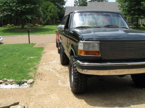 1994 Ford Bronco - Front view of a 1994 Ford Bronco with a chrome grille and aftermarket wheels.